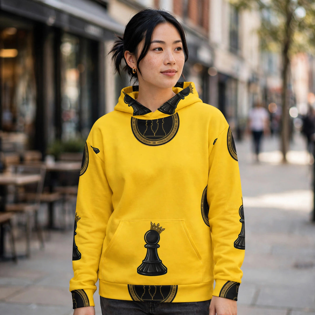 Yellow all-over-print hoodie with black Duo Seal medallion and crowned pawn, city sidewalk